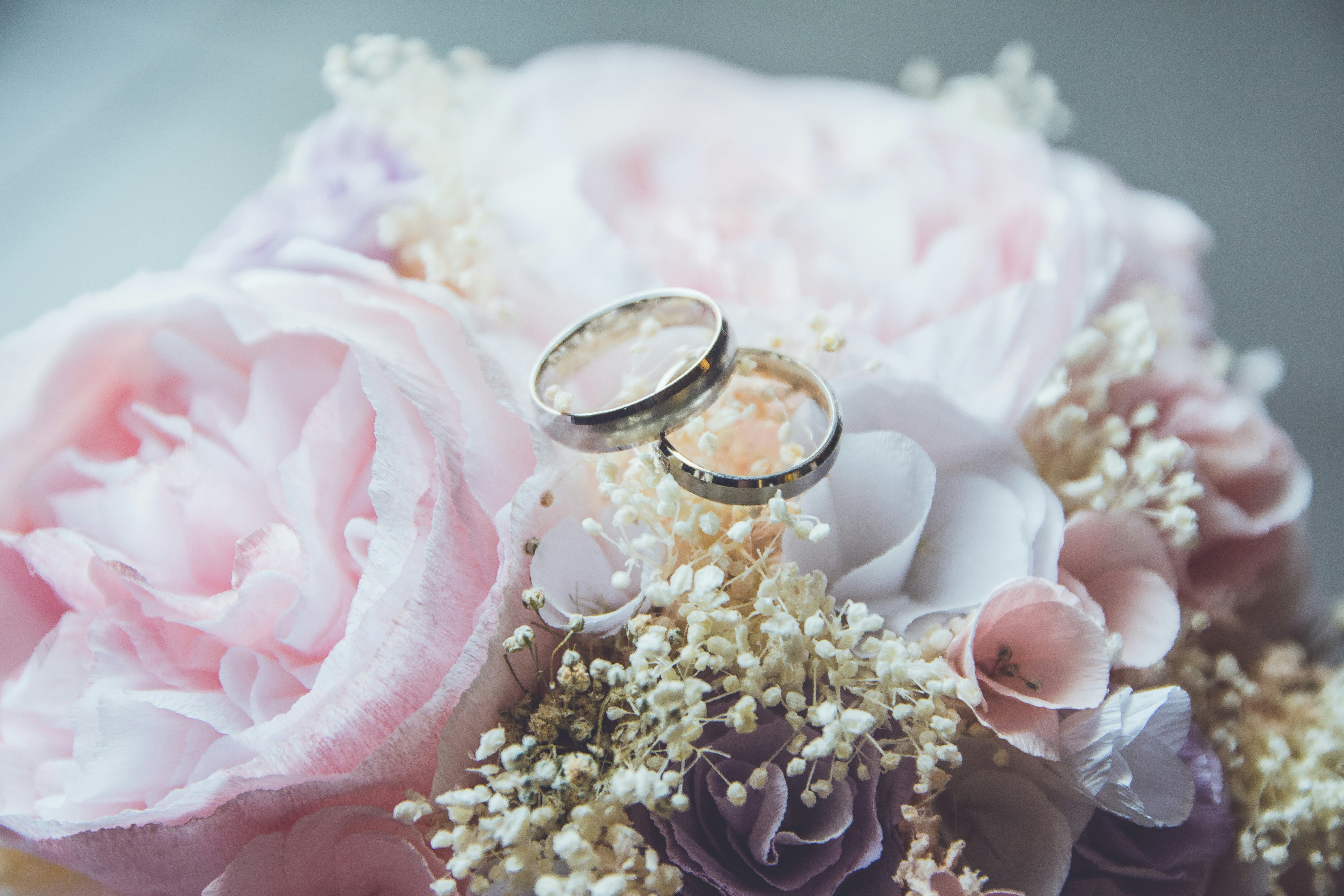Two wedding rings resting on a soft arrangement of flowers